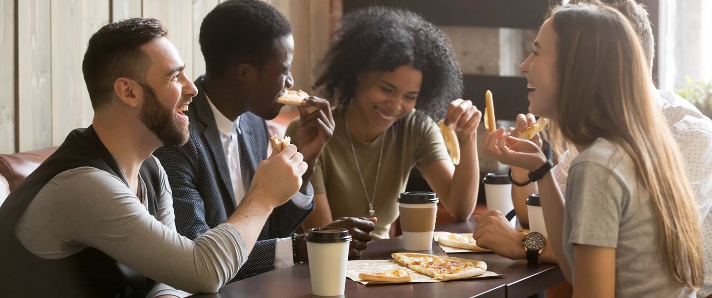 Friend eating pizza and smiling