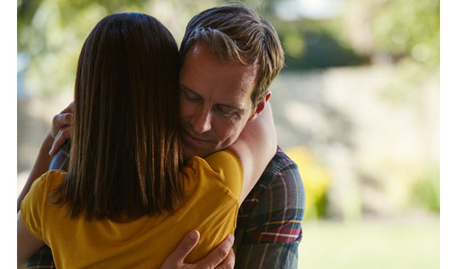 Man and woman hugging at the park