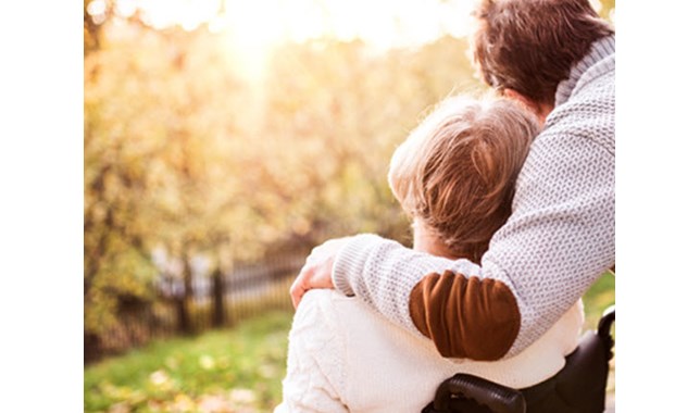 Man hugging woman in wheelchair